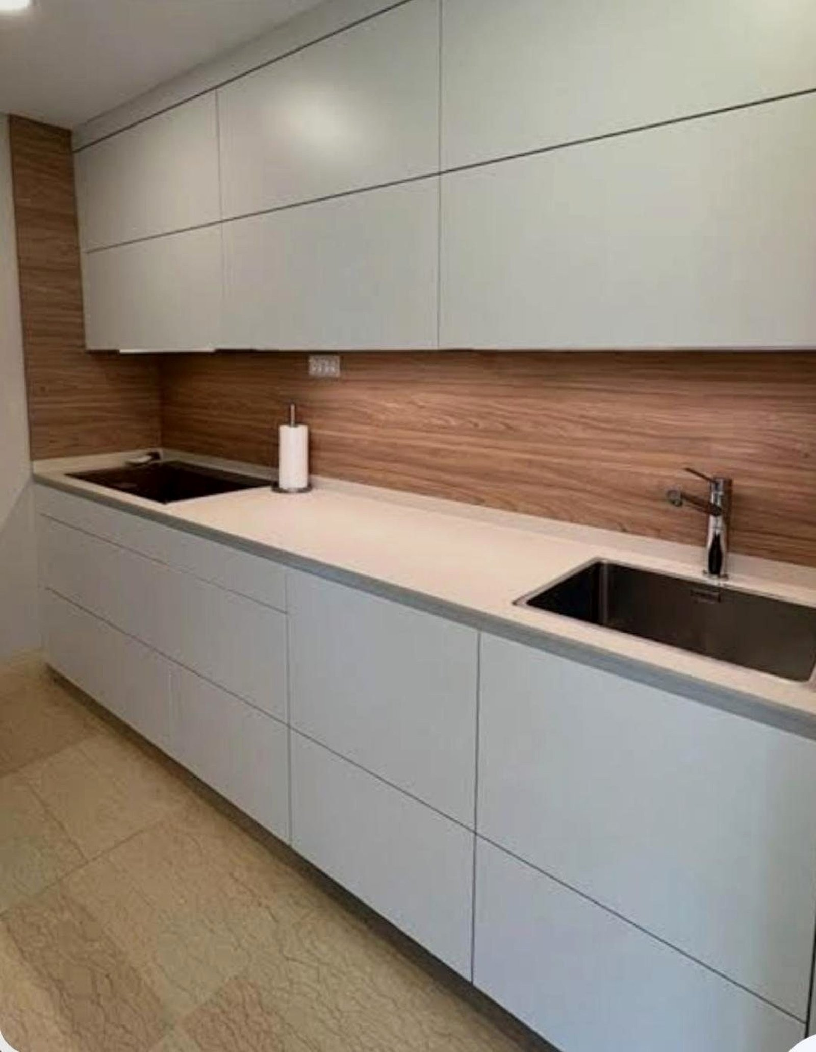 Cocina reformada con muebles claros y frente de madera
