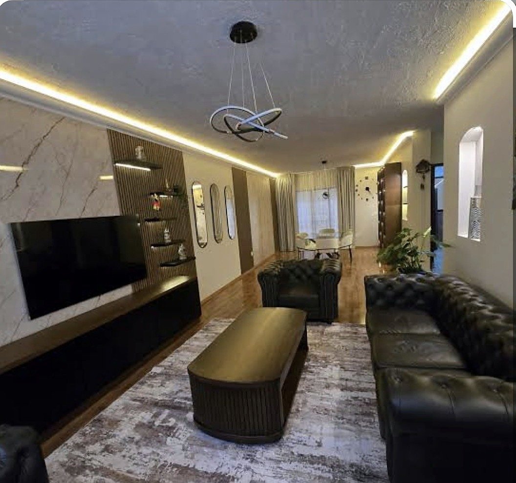 Salón terminado con iluminación lineal y mobiliario a medida